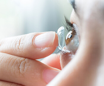 Woman putting on scleral lenses from Premier Eyecare Associates