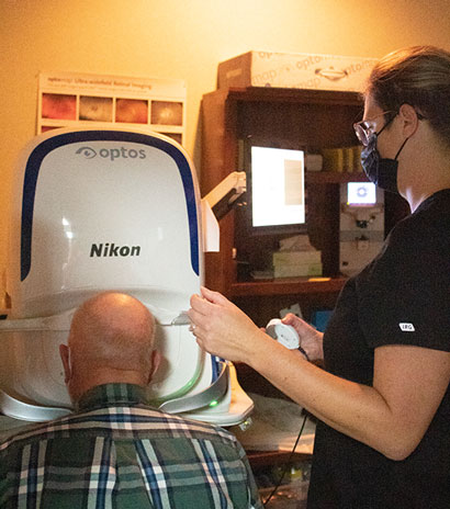 Elderly getting an eye test for macular degeneration using NIKON Optos
