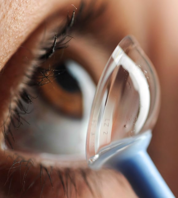 Woman putting in scleral contact lenses at Premier Eyecare Associates