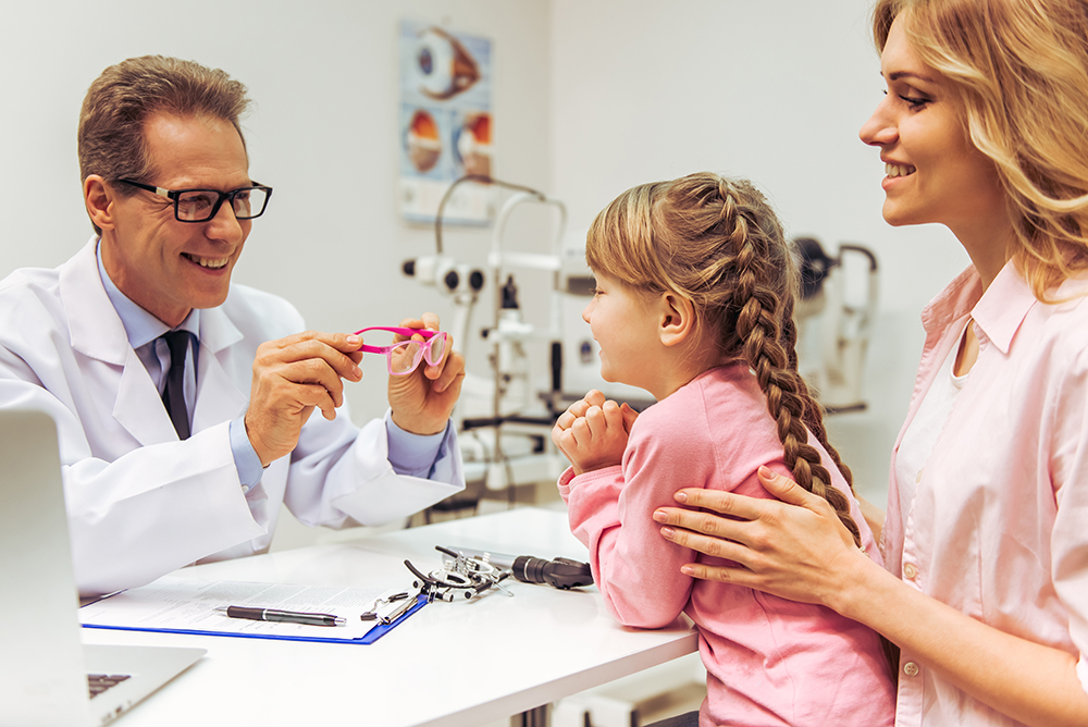 Nice,Little,Girl,And,Her,Mother,At,The,Ophthalmologist,On Happy little boy with mother giving a high five to eye doctor
