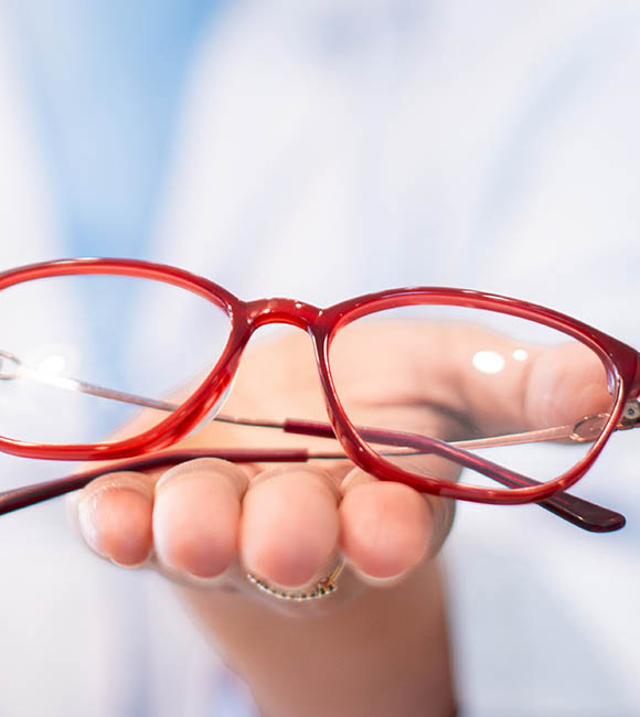 Hand holding glasses with progressive lenses