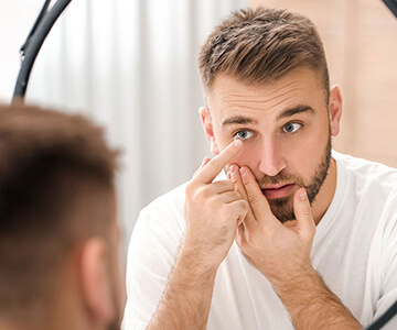 Man putting on scleral lenses from Premier Eyecare Associates